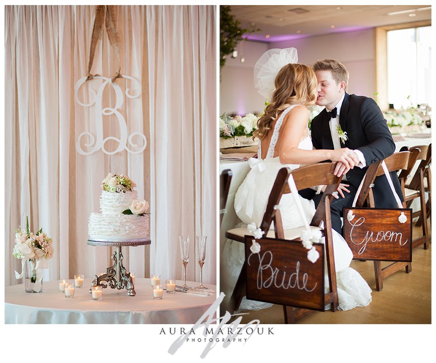 Large B monogram hang above the white two-tier cake. Wooden bride and groom signs mark the head table. © Aura Marzouk Photography, Greensboro Wedding Photographer