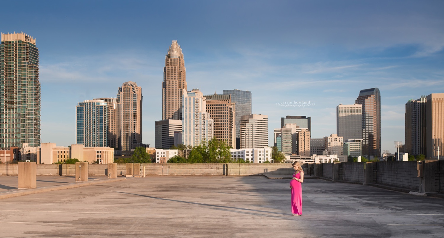 panoramic photo maternity of pregnant lady standing in front of the Charlotte, NC skyline