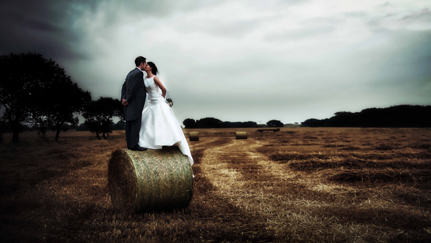 Bride and Groom on haystack, unusual wedding photography