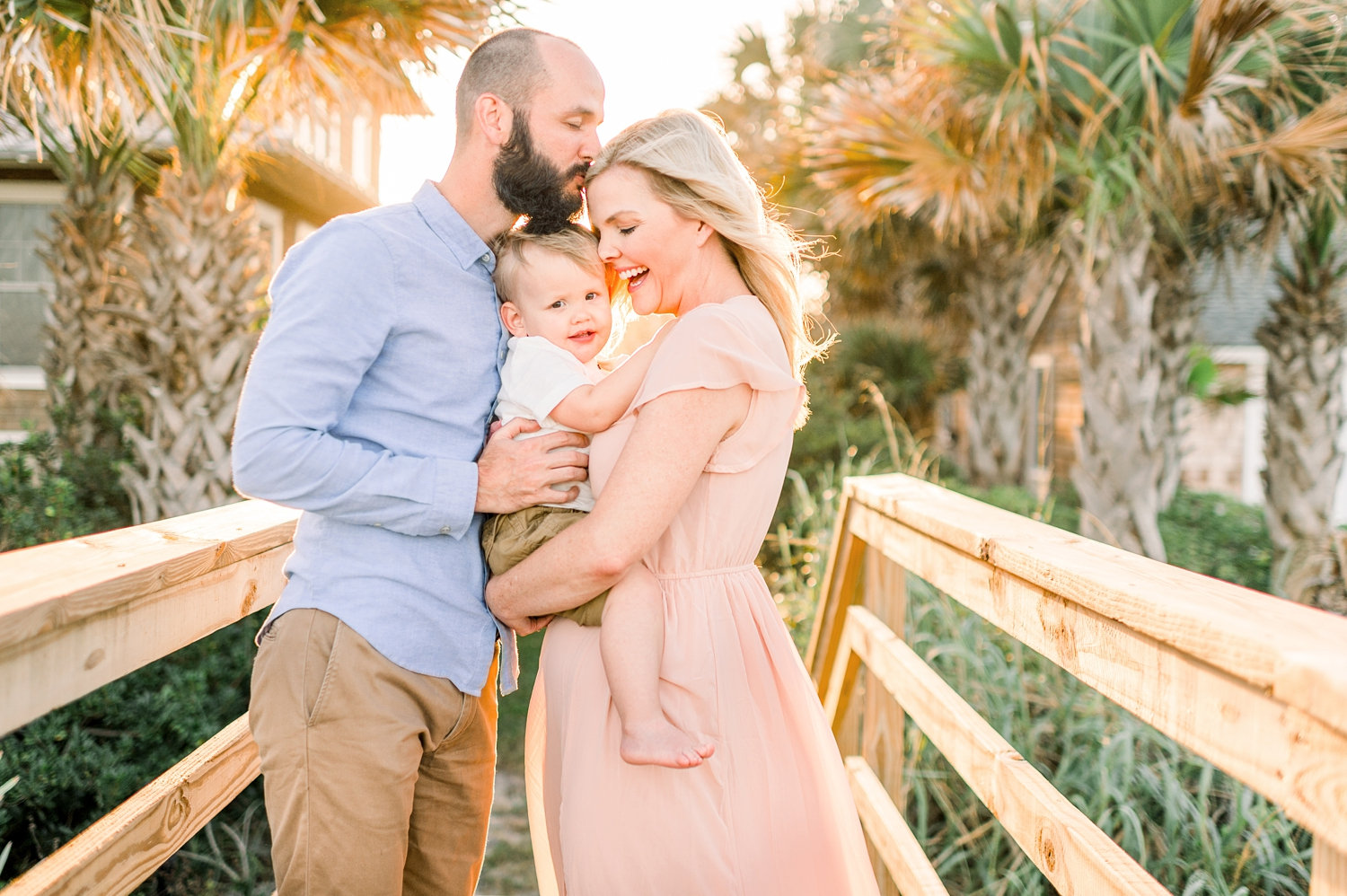 father kissing mother's forehead, man with a beard, little boy, blonde woman, Florida beach, Rya Duncklee