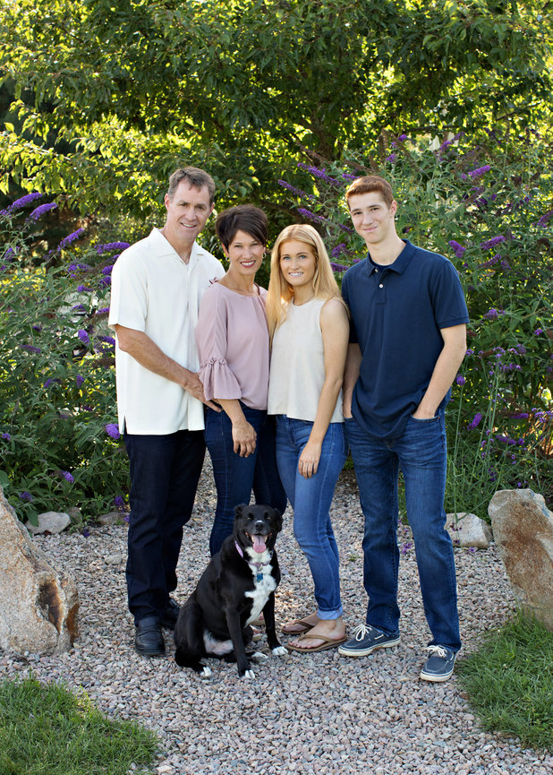 outdoor family portrait with parents and young adult children and dog in garden with rock pathway Millis ma