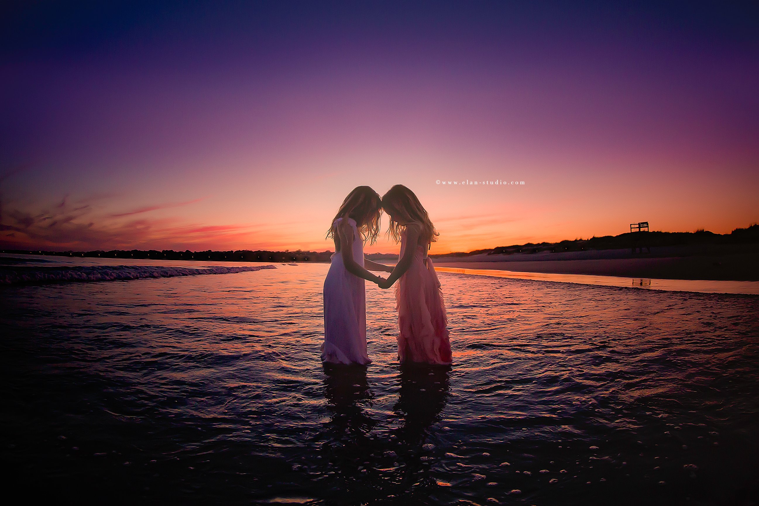 twin sisters grasping hands, standing in water, Rhode Island coast, Elan Studio