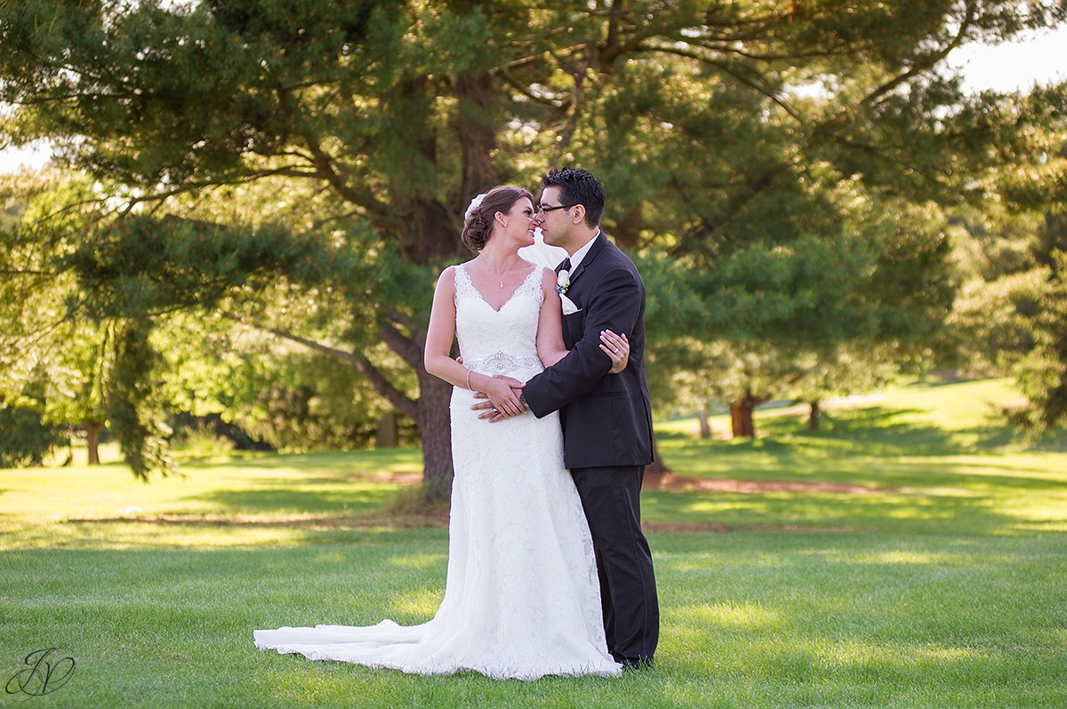 bride and groom noses touching golf course