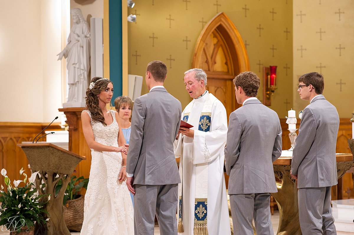 bride and groom exchanging vows during church ceremony