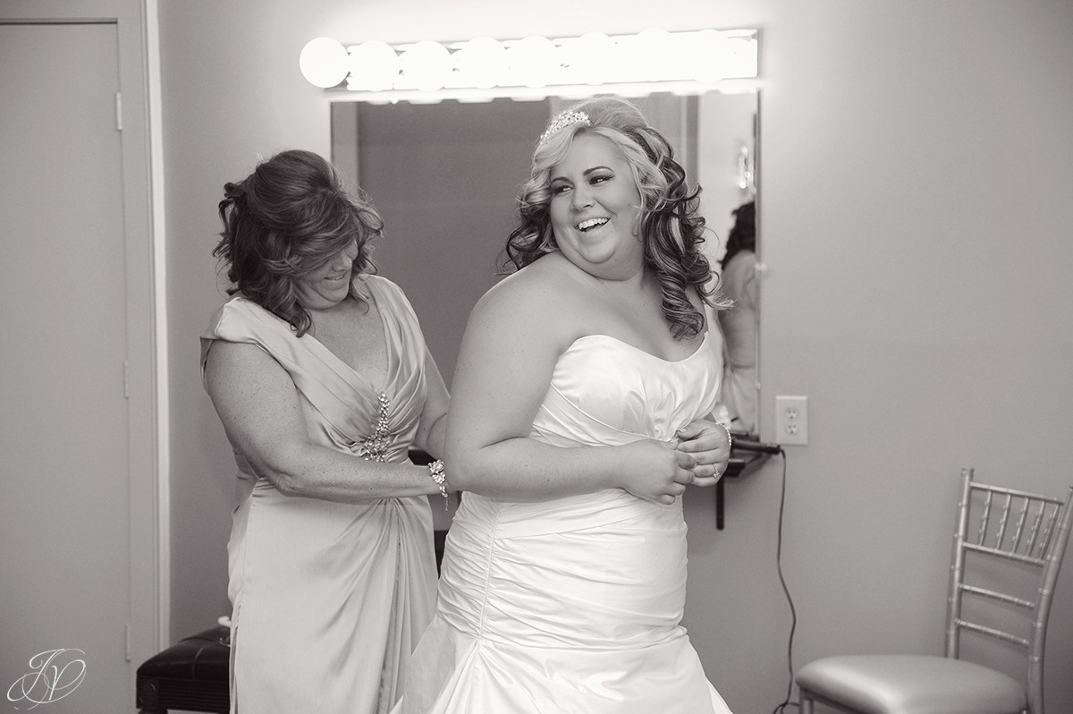 fun shot of bride's mom helping bride get dressed