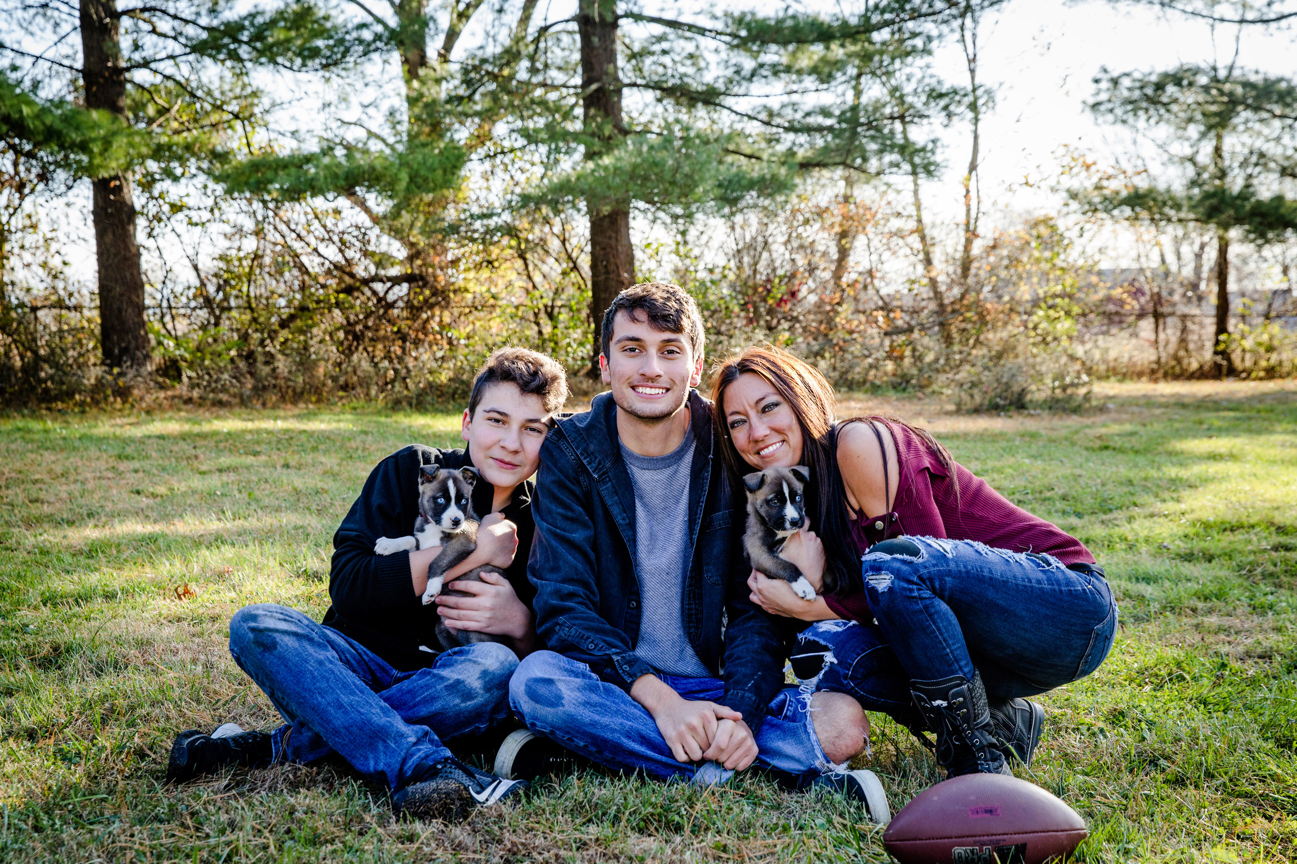 mother and two sons enjoying outdoors with two pups