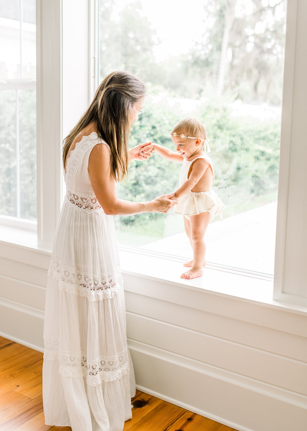 mom and toddler daughter standing together, holding hands, window portraiture, Rya Duncklee Photos