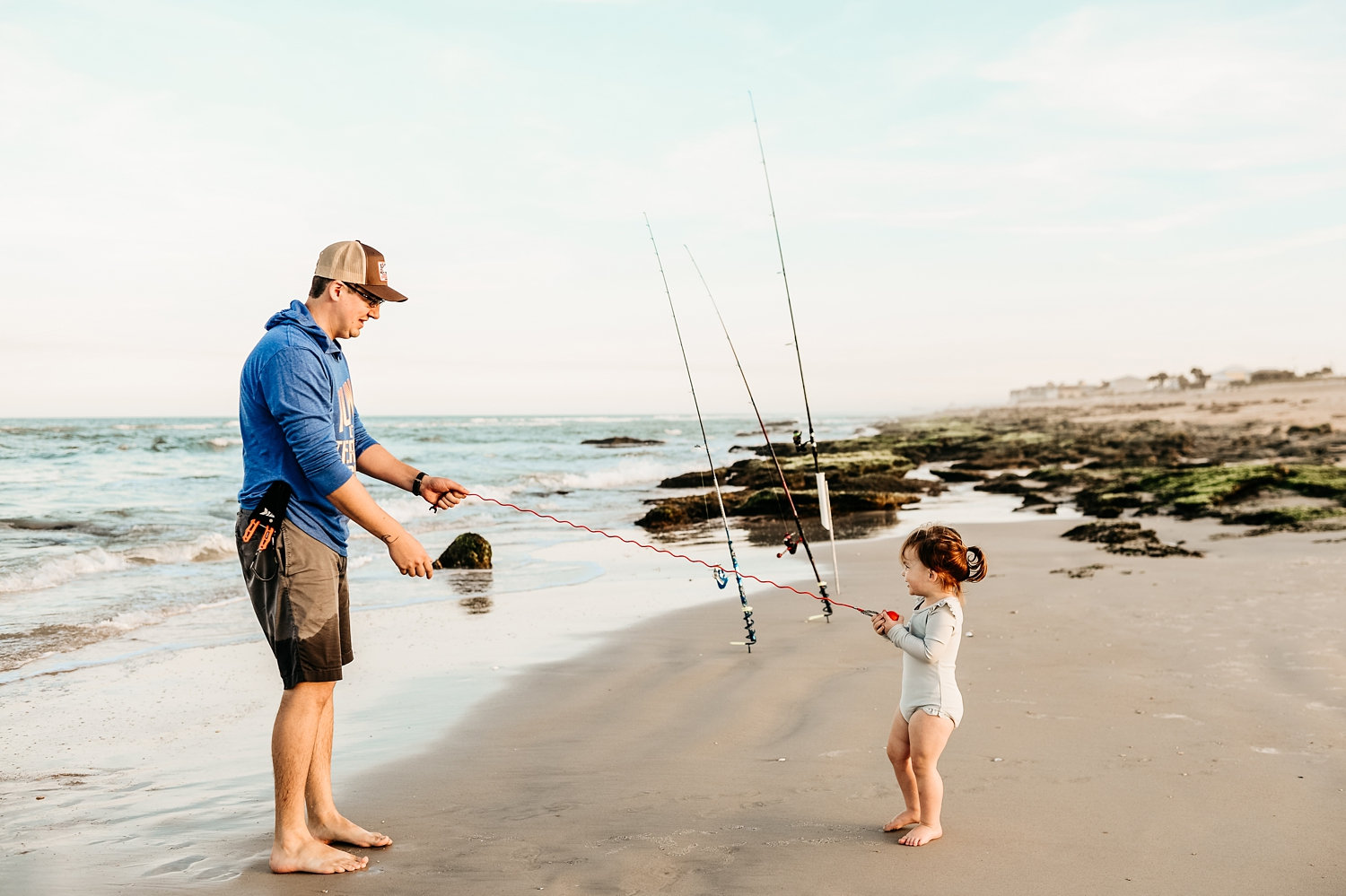 father and little girl having fun fishing on a Florida beach, Ryaphotos