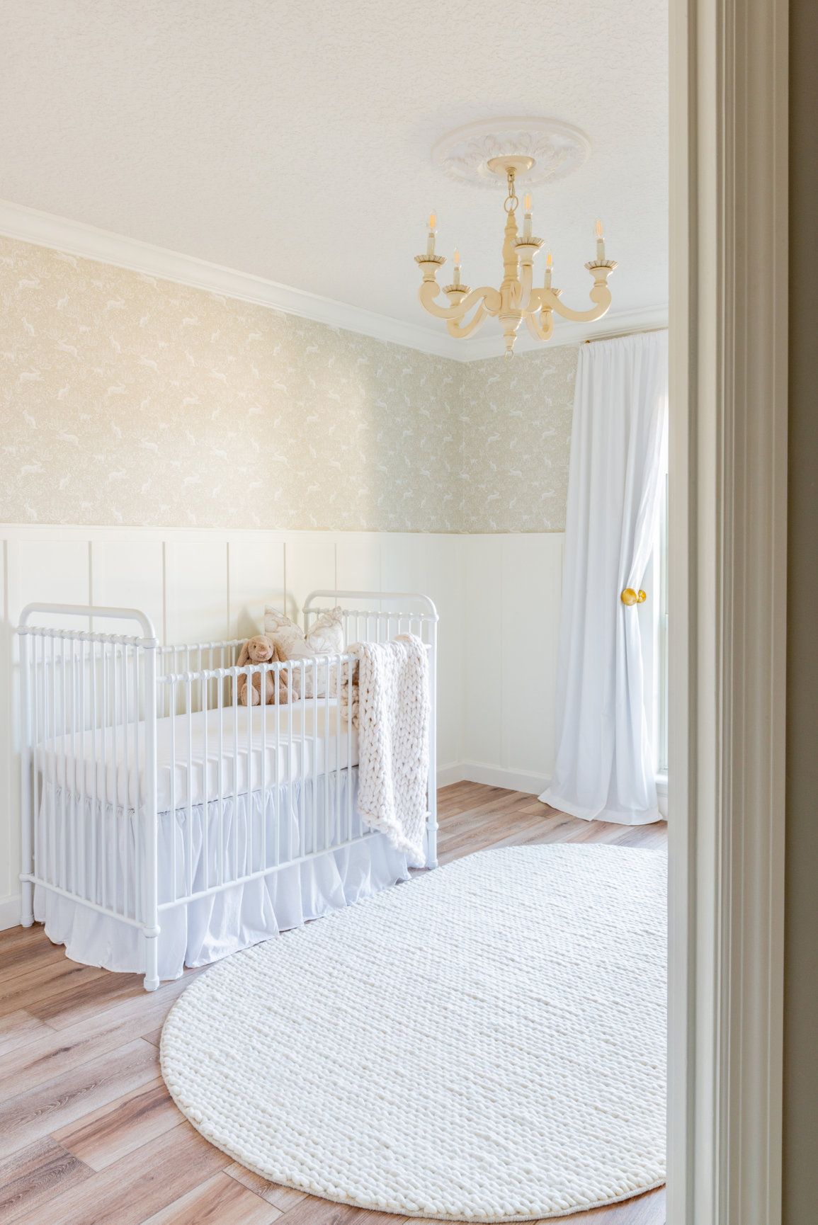 looking into a French Farmhouse style nursery, rustic wood flooring in a nursery