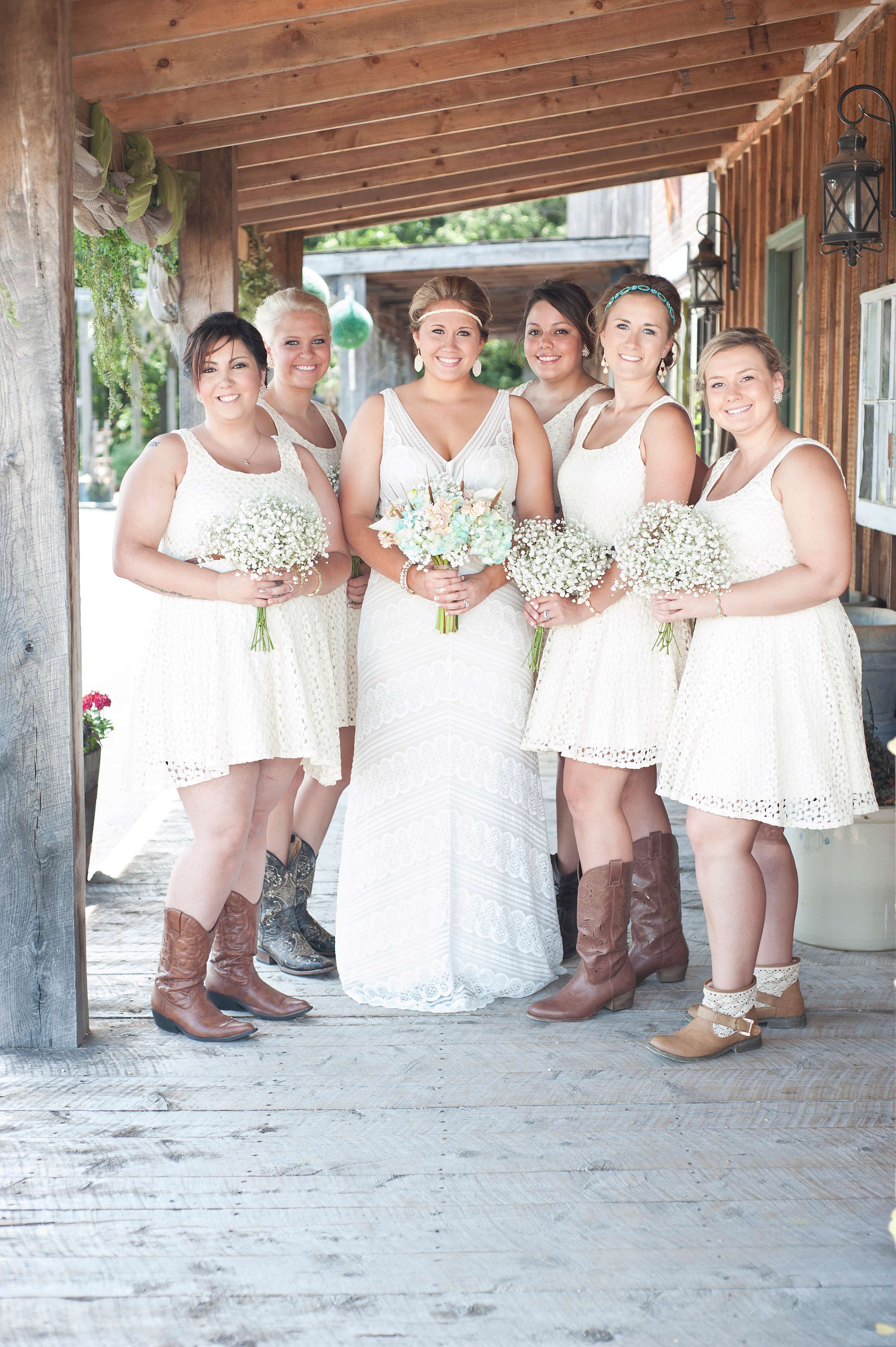 Bride holding bouquet posing for photo with her bridesmaids.