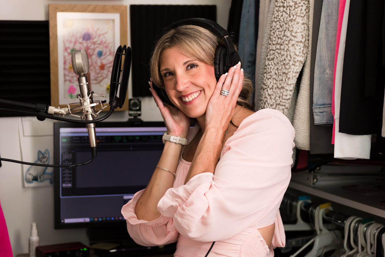 small business owner voice over talent stands in home office with microphone and headphones for lifestyle headshot during brand session