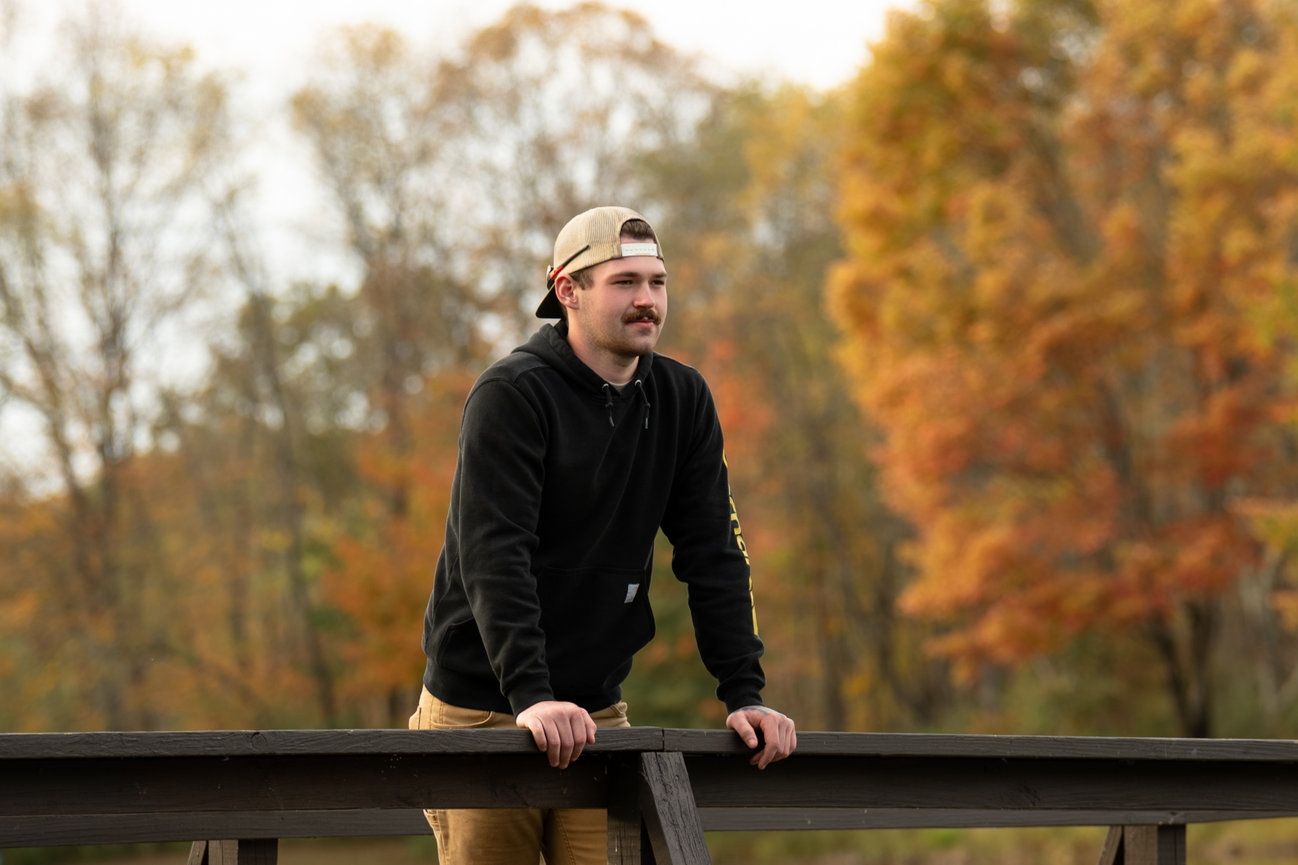 senior guy pictures near a lake outside of butler pa during the fall