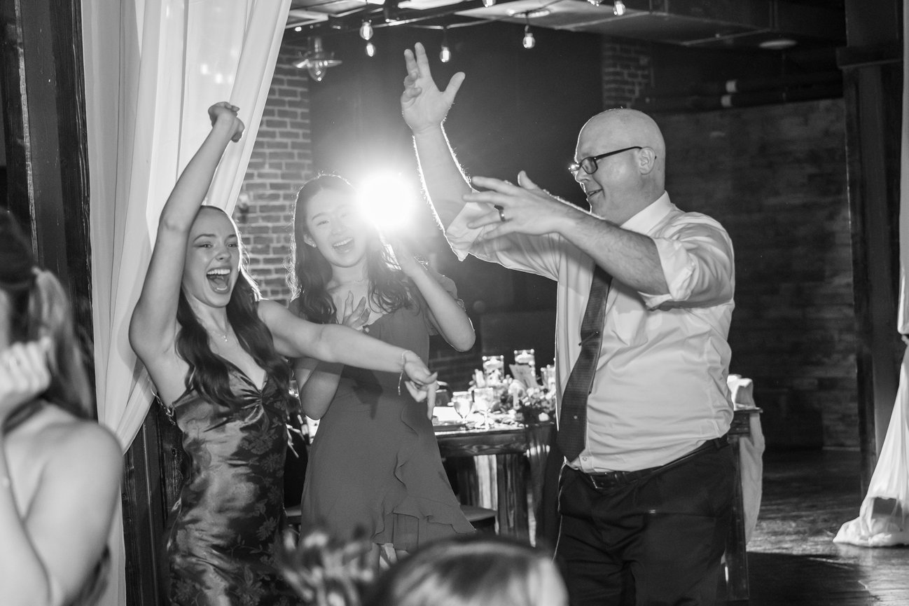 People dancing and celebrating at a lively indoor party with bright backlighting