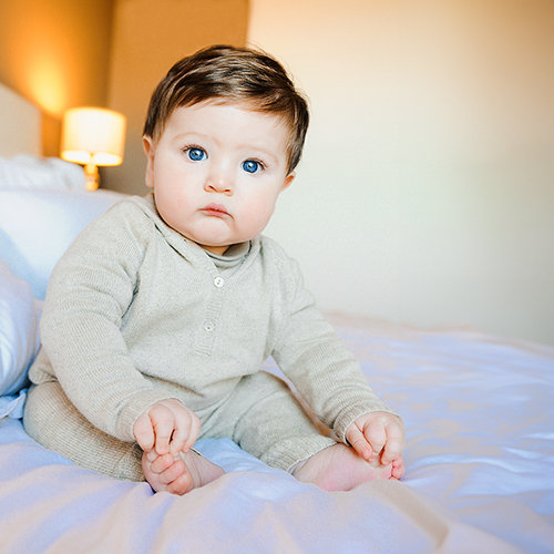Portrait of 6 month old baby on a bed