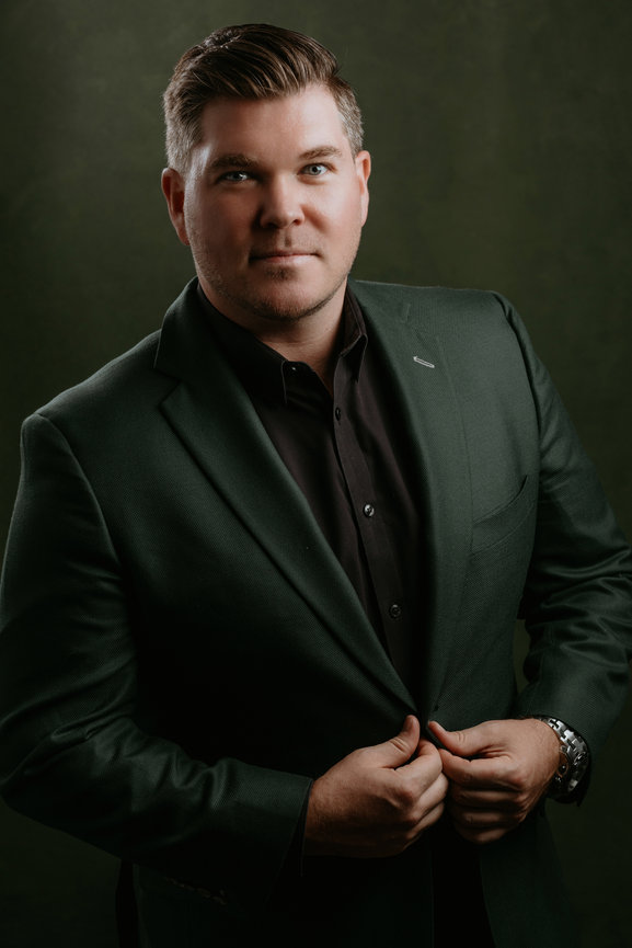 Striking professional male headshot with green suit and green backdrop. Professional headshots and team portraits in studio with Adam Trujillo.