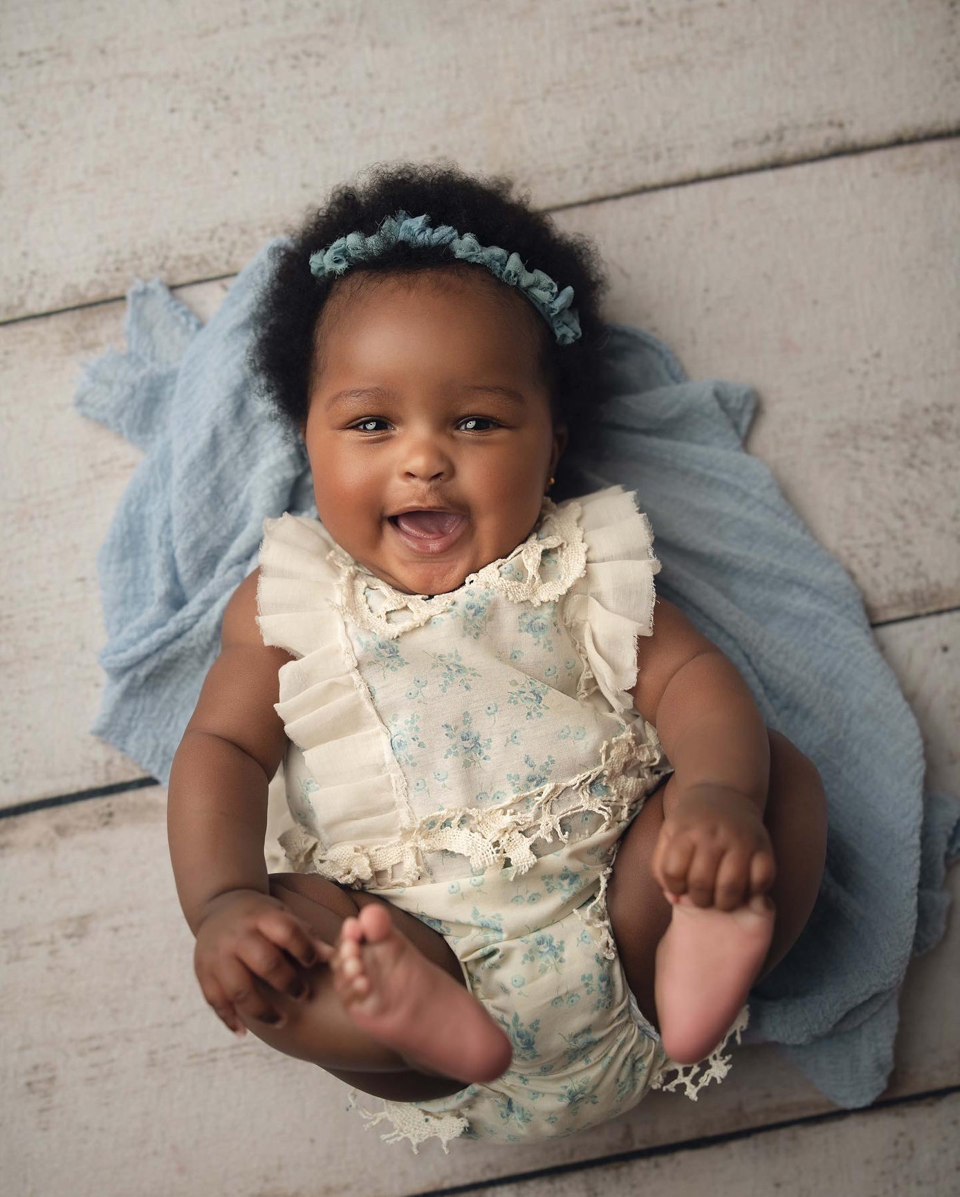 Smiling baby in a blue floral romper