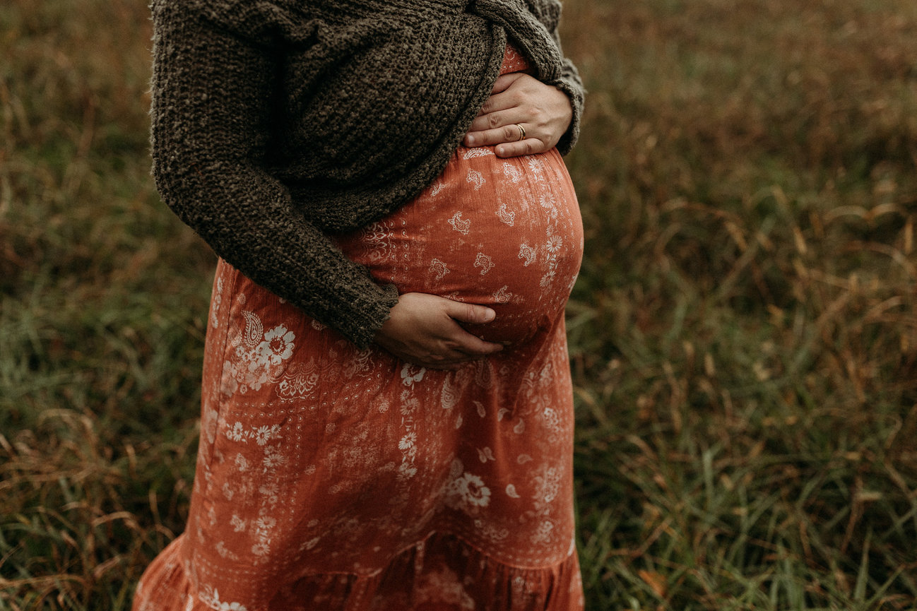 Maternity photoshoot with woman in orange dress in Huntsville, Alabama