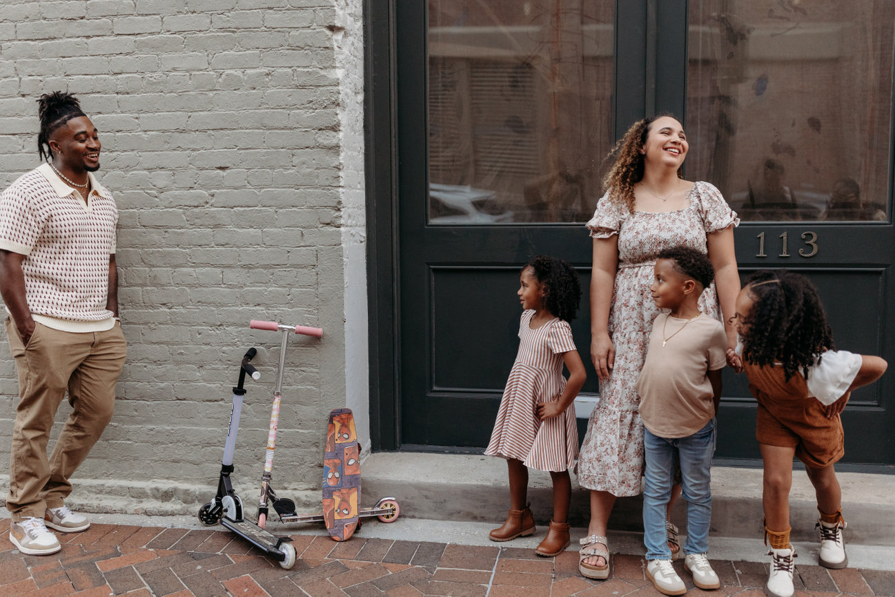 Huntsville Alabama photoshoot Black family stand on brick downtown sidewalk