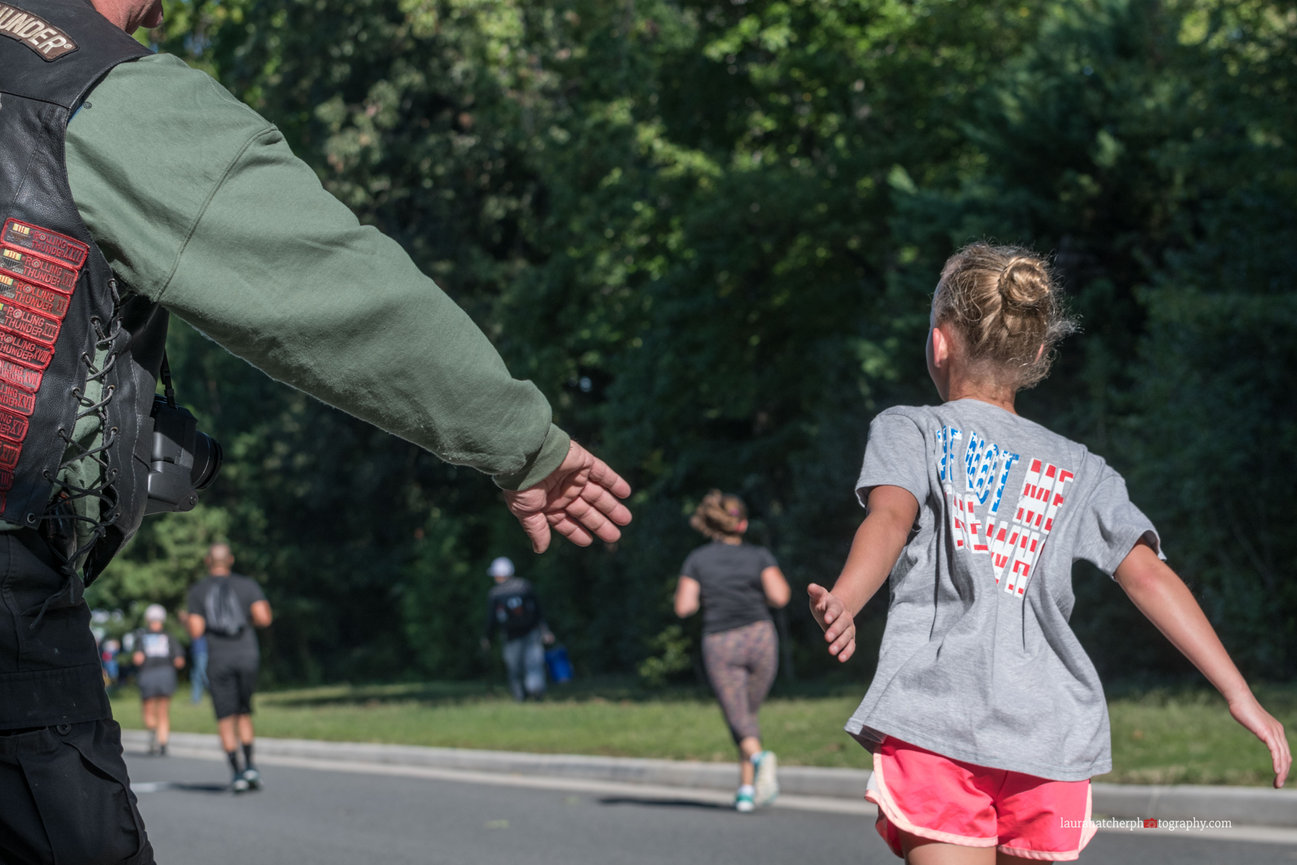 A veteran holding out his hand during a 5K run