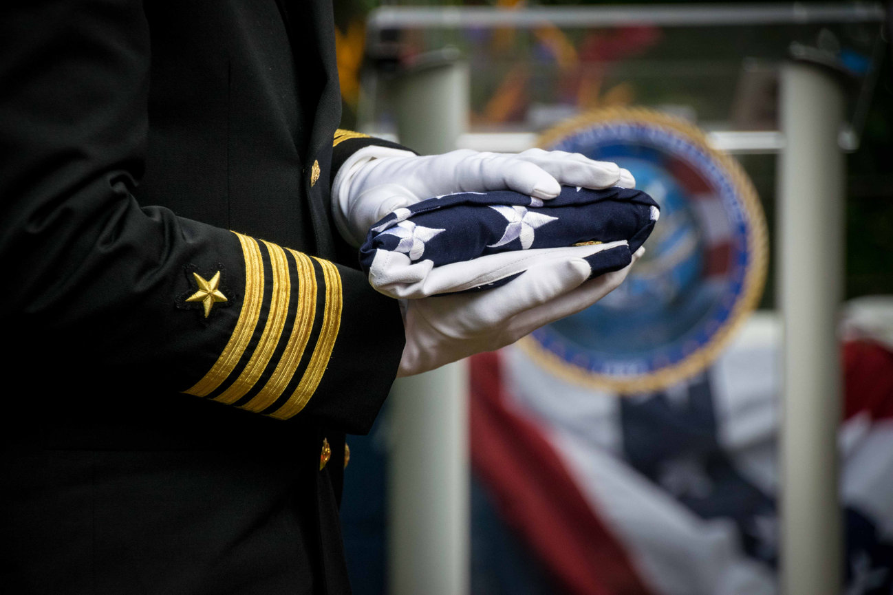 Navy Captain holding a folded American flag during a retirement ceremony