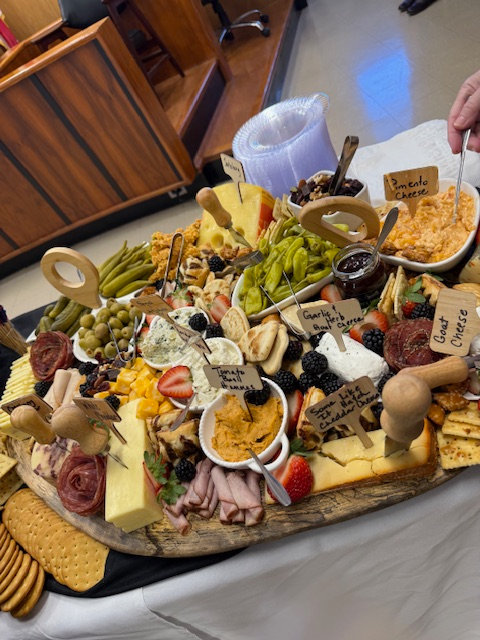 Charcuterie board with labeled cheeses and meats