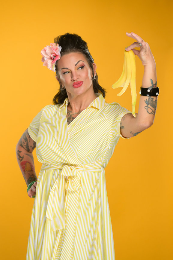 Creative women's portrait session Orlando - woman in yellow striped dress holding banana peel against yellow background, She's More Than by Karen K Photo