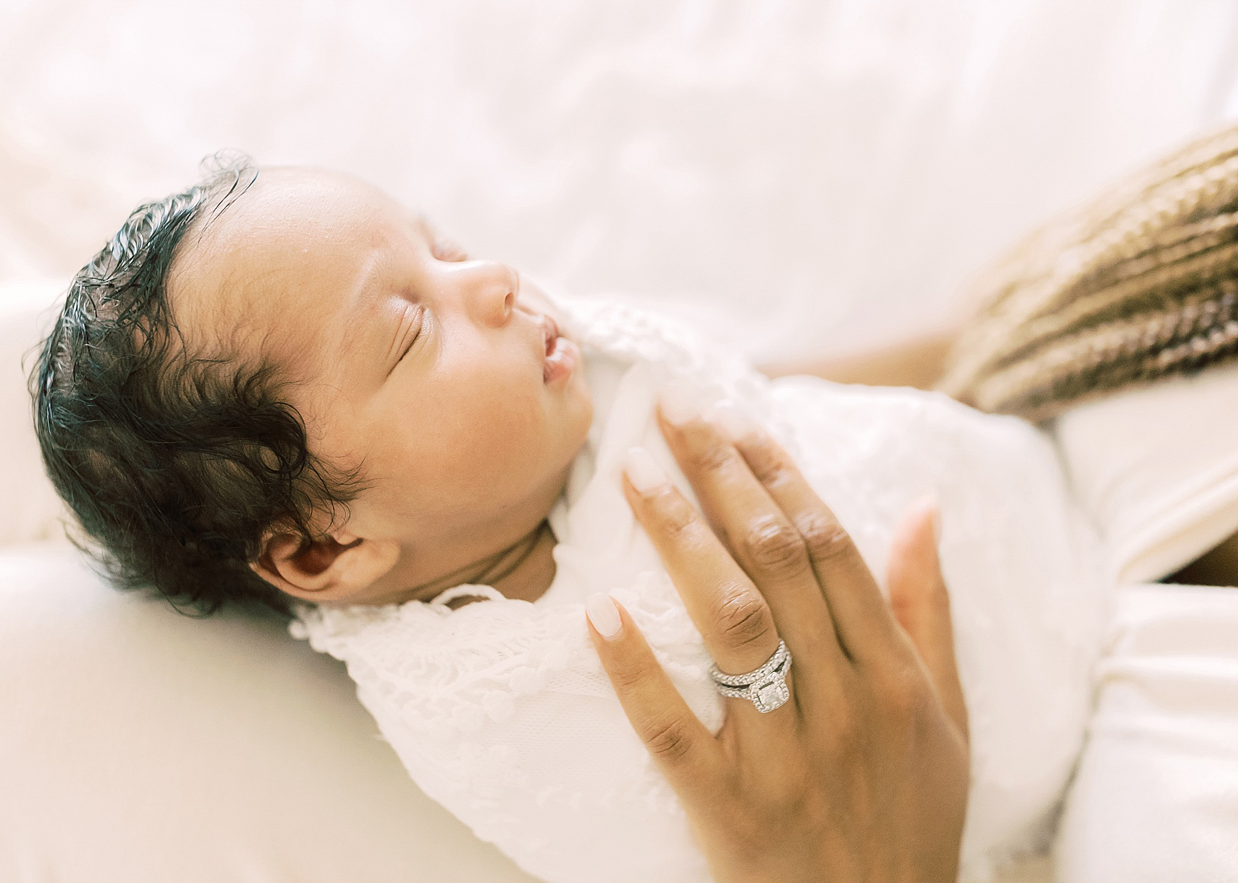 newborn baby girl on bed against light and airy white sheers window light
