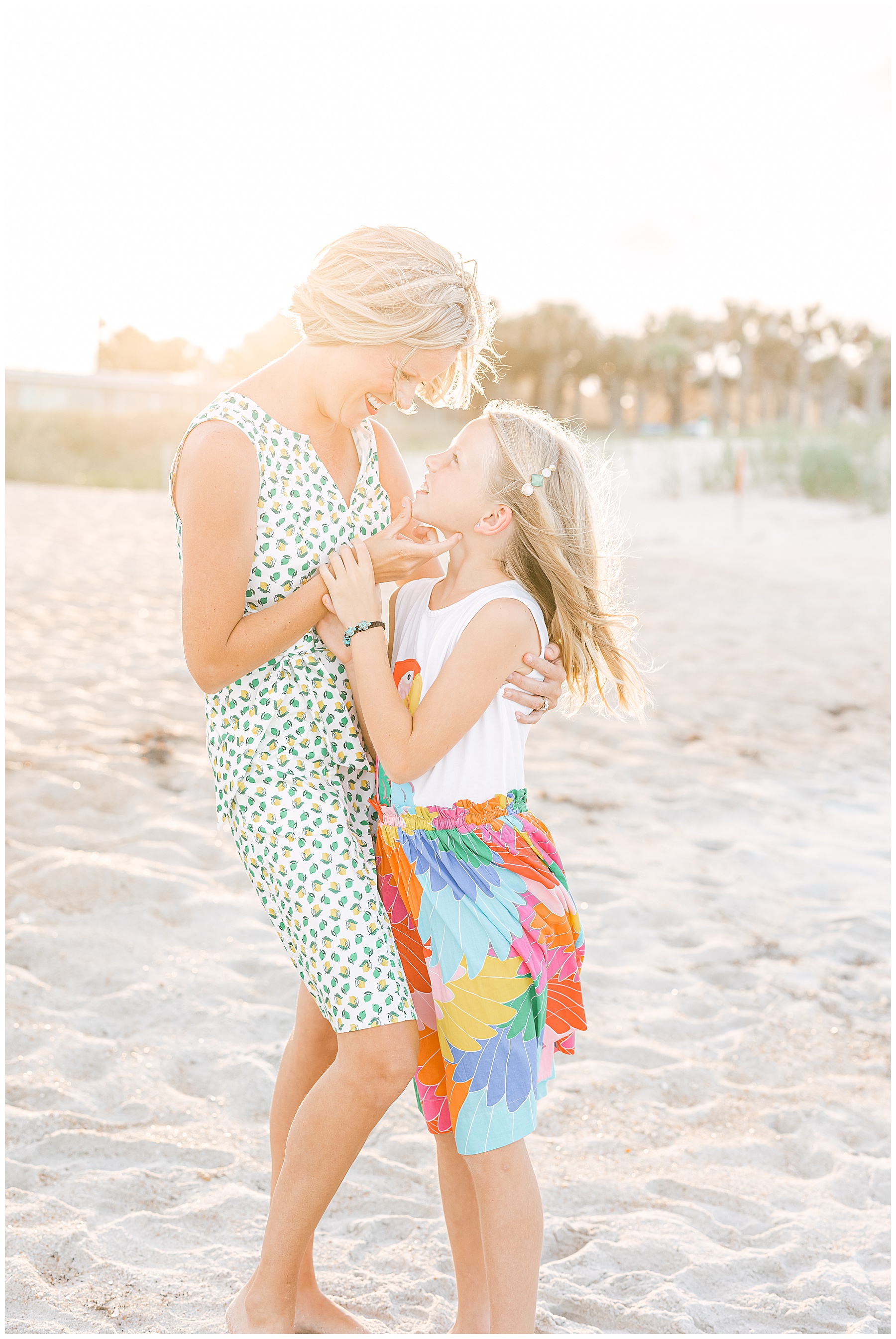 woman and daughter standing on the beaches of vilano florida holding each other in the backlit afternoon sun in the summer