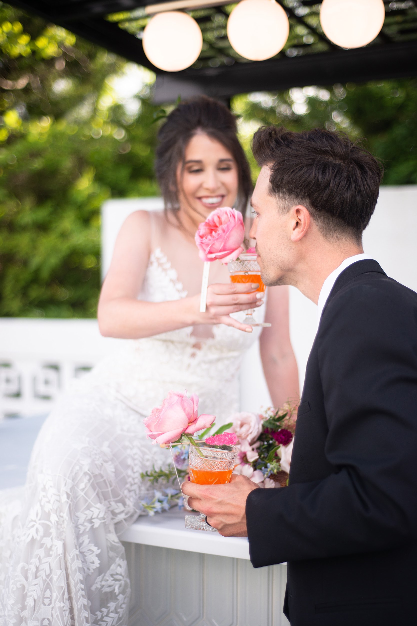Bride letting groom smell her orange drink.