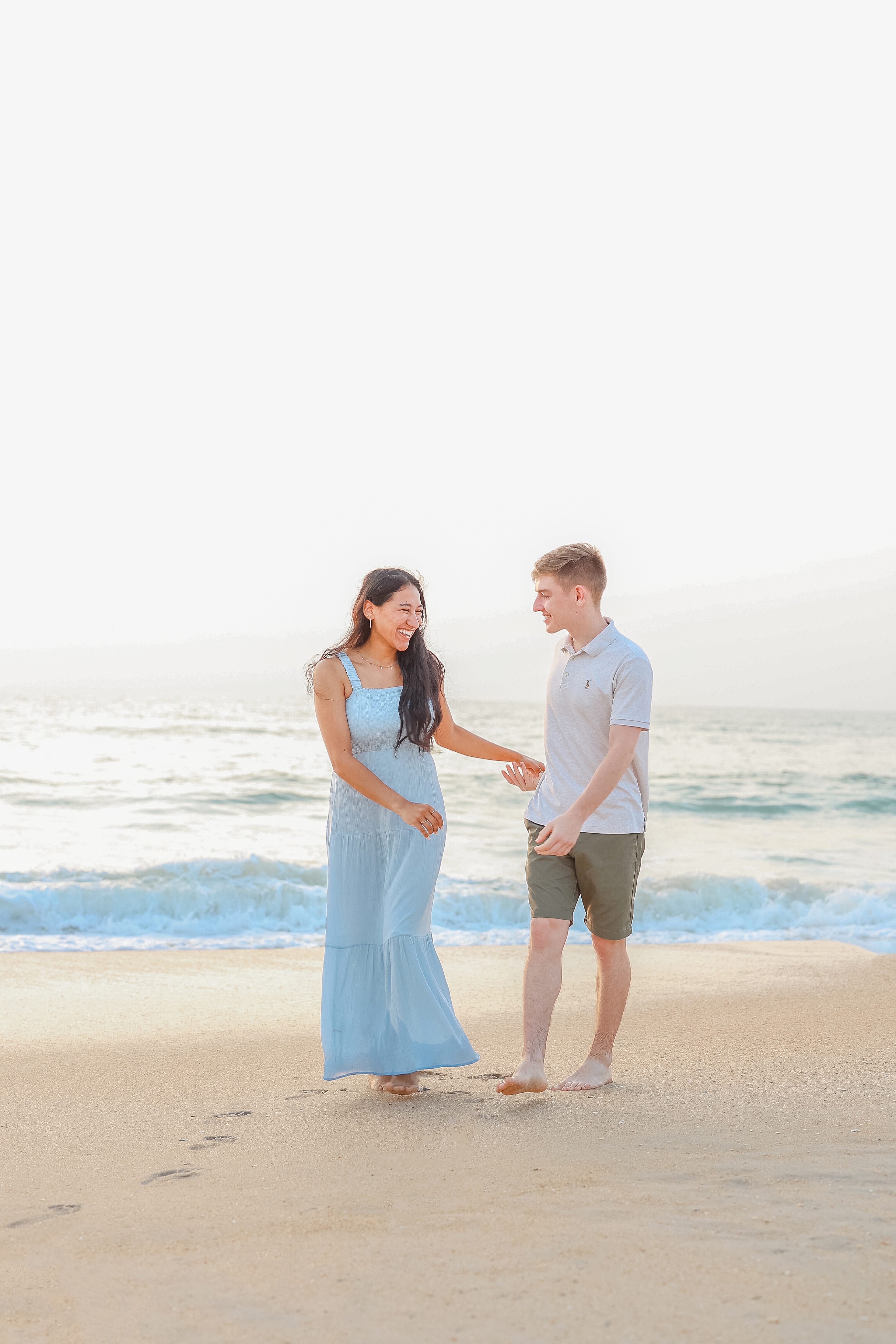 a young couple dancing near the water in the ocean