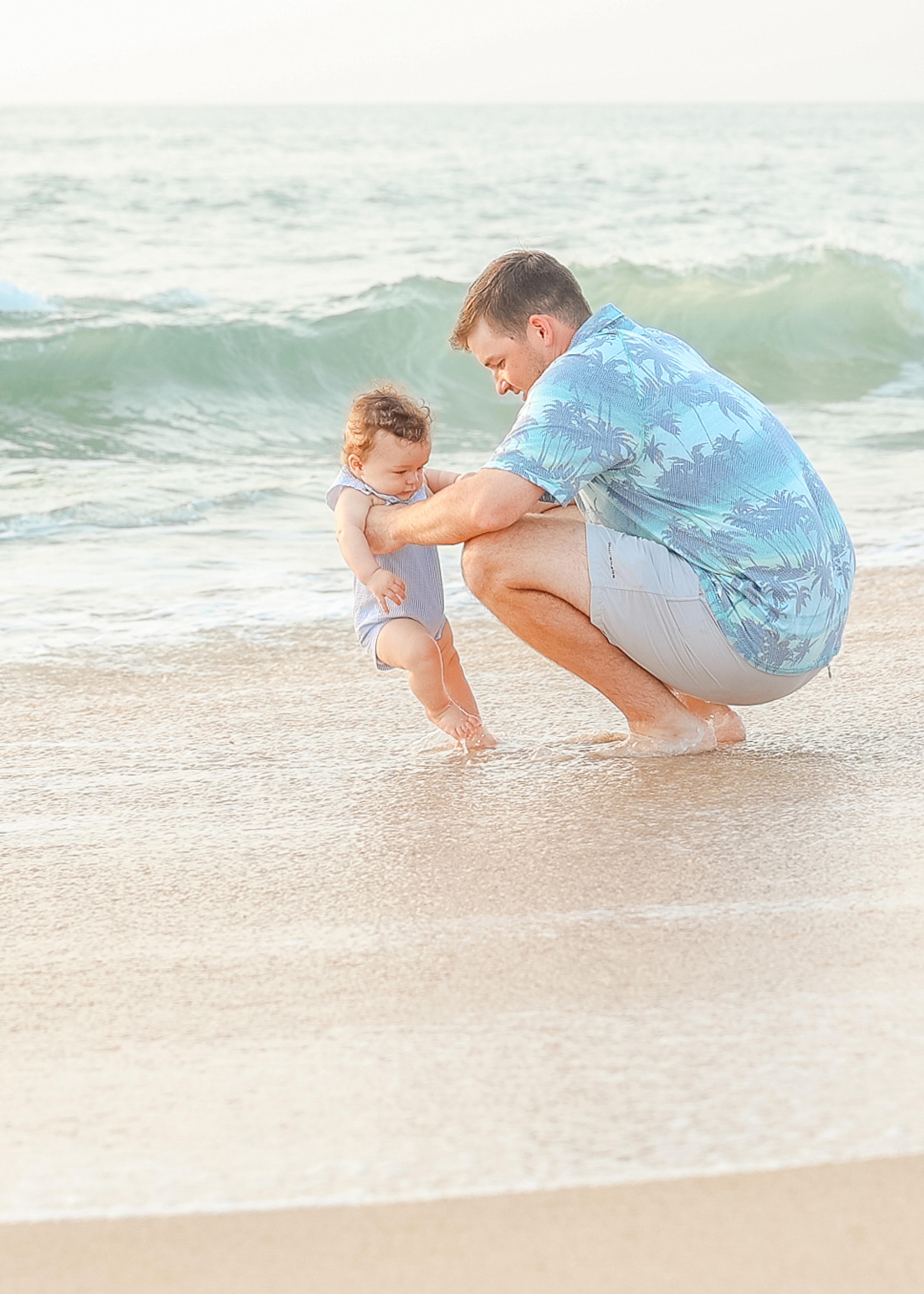 light and airy beach portrait of a father and baby at the beach