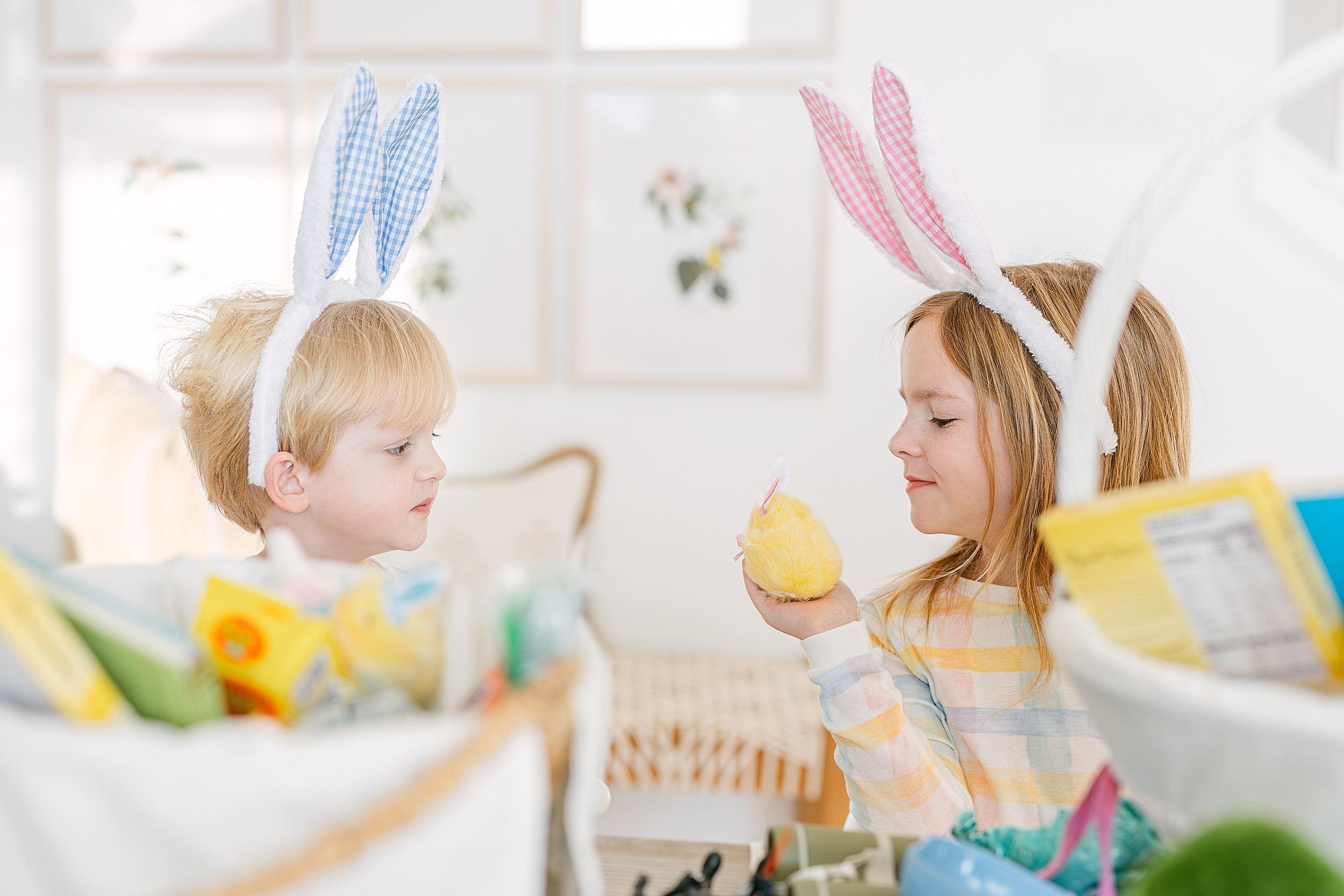 Two little children look at each other on Easter wearing pastel pajamas.
