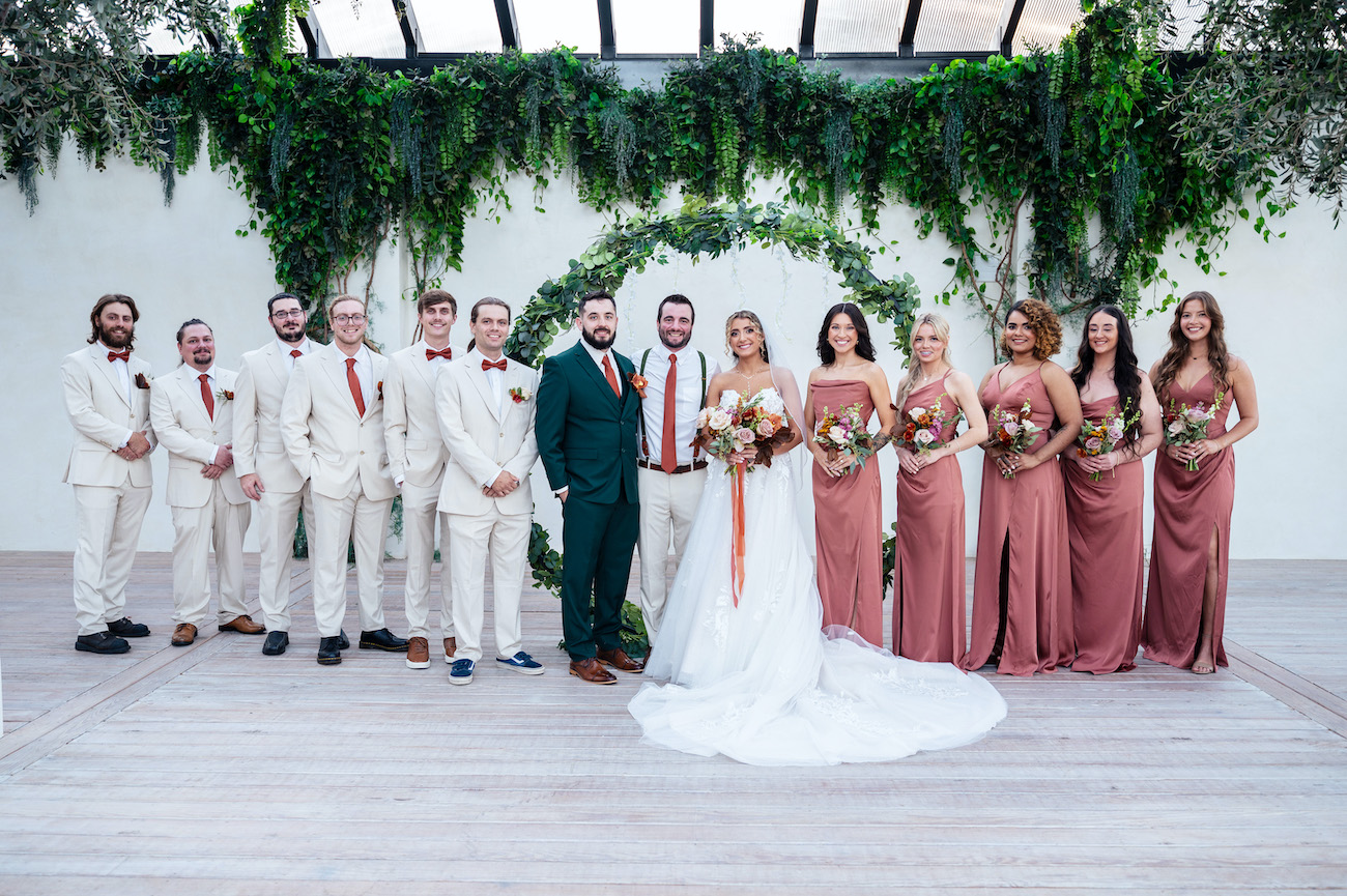 Wedding party posing for formal photo after their fall wedding.