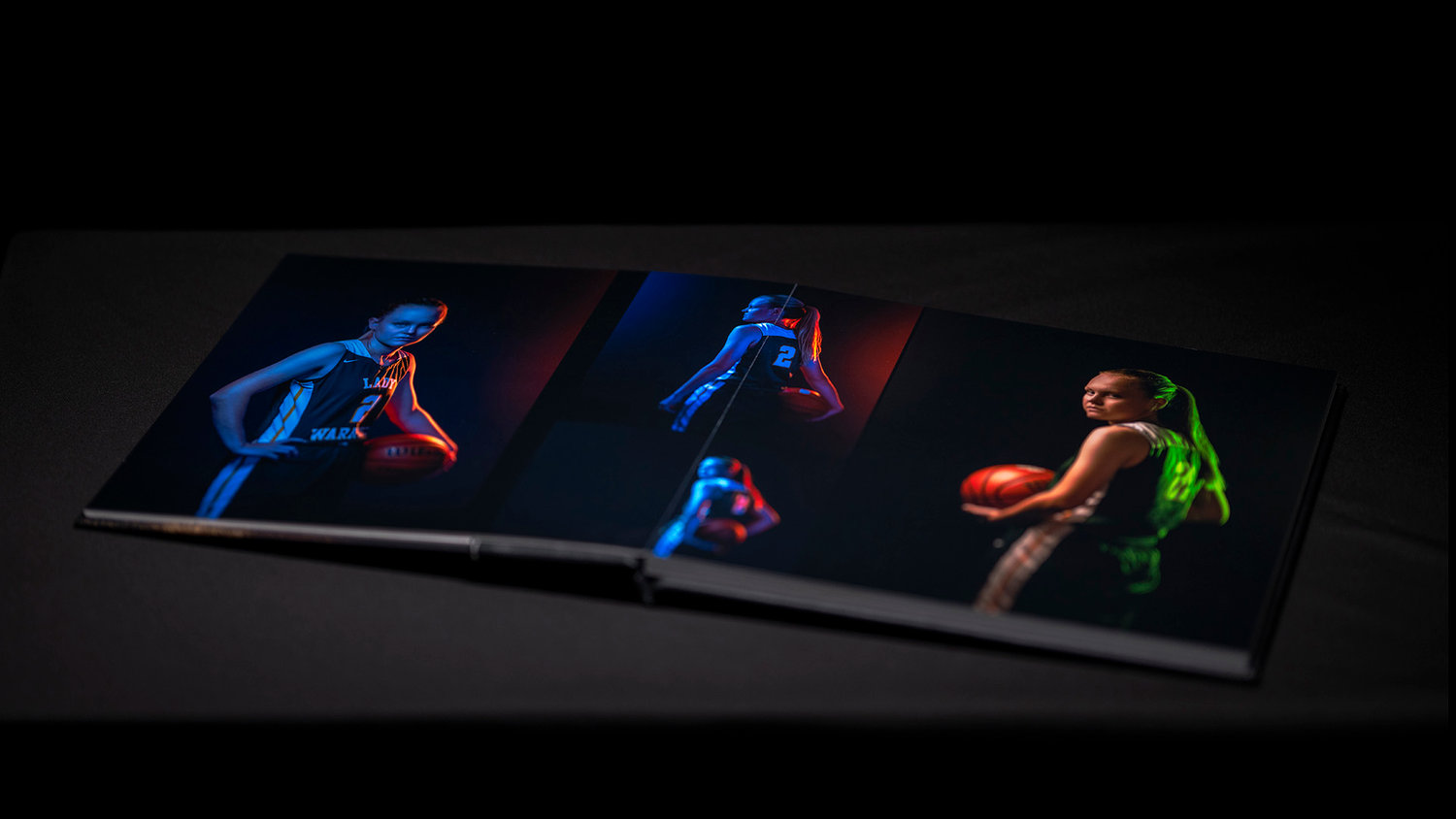 Open photo album with vibrant images of a basketball player in colorful lighting on each page.