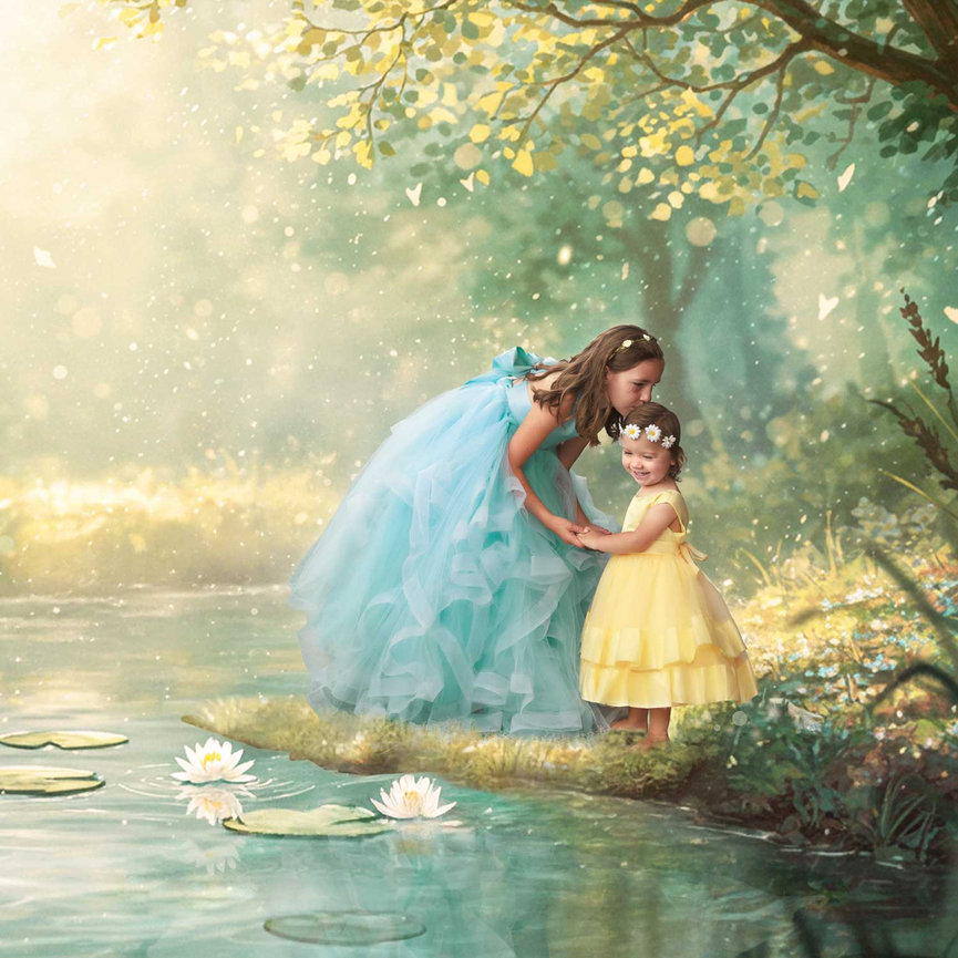 Two girls in pastel dresses standing by a pond in a magical sunlit forest.