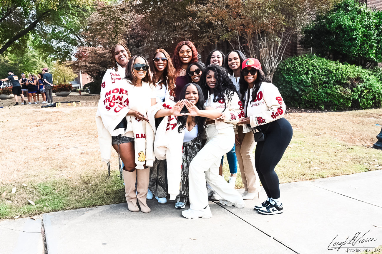 A group of women smiling and posing together for a photo, showcasing friendship and camaraderie.