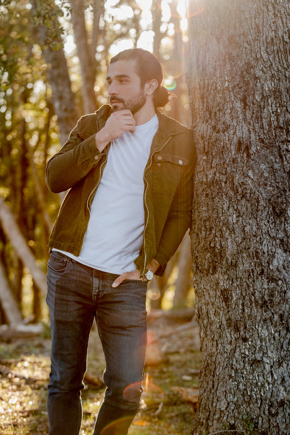 Outdoorsy male in jeans and jacket leaning on tree and backlit by the sun by Southern California Lifestyle Photographer Stefanie Blue.