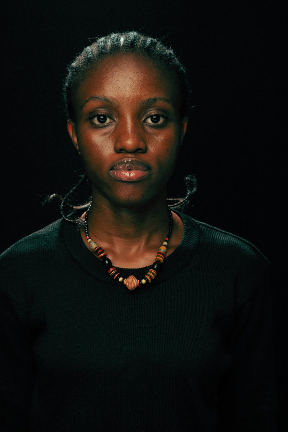 Woman in black top against dark background