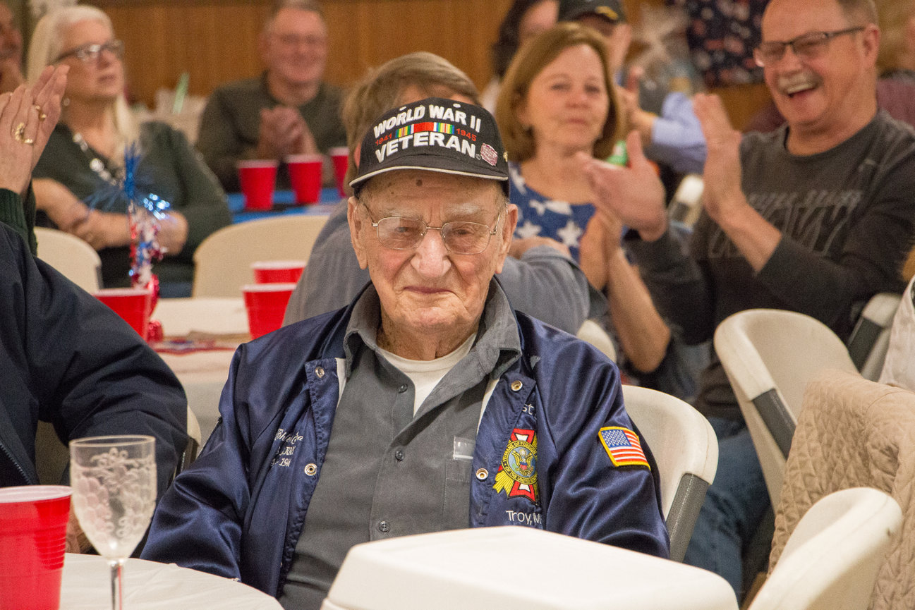 World War II Veteran being honored during an event with people clapping in background