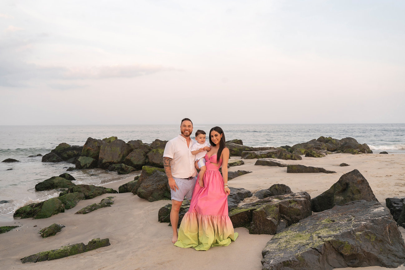 Perfectly posed family smiling directly at camera in soft light