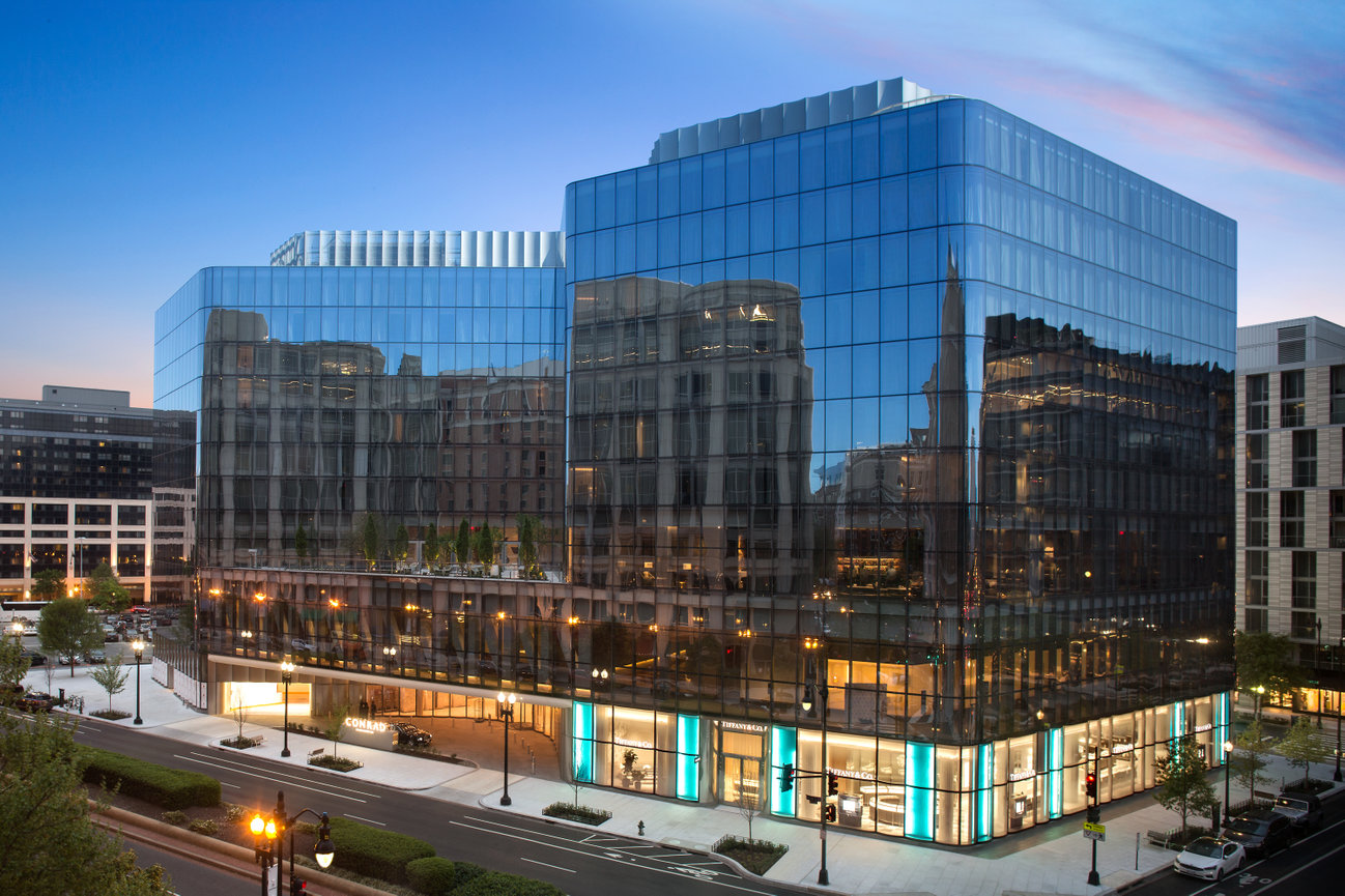 Evening Exterior of The Conrad Hotel Washington DC beautiful Glass structure with colors of Tiffany Store below.