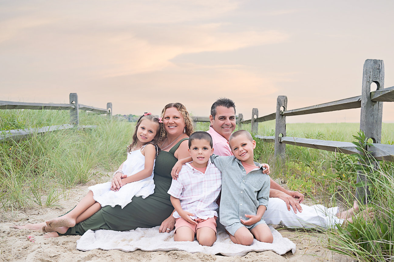 Child framed between parents with blurred beach backdrop