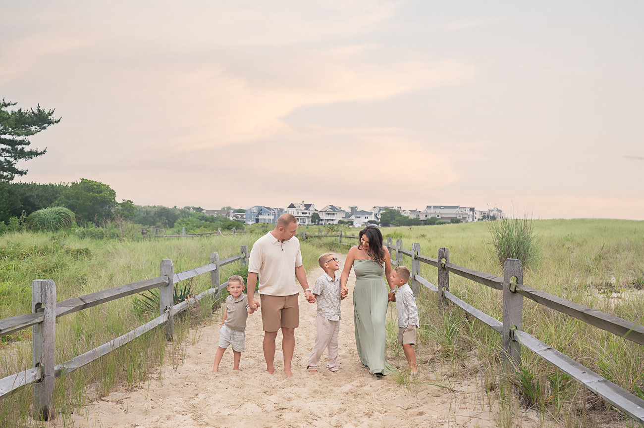Family walking down green-lined beach path in Point Pleasant