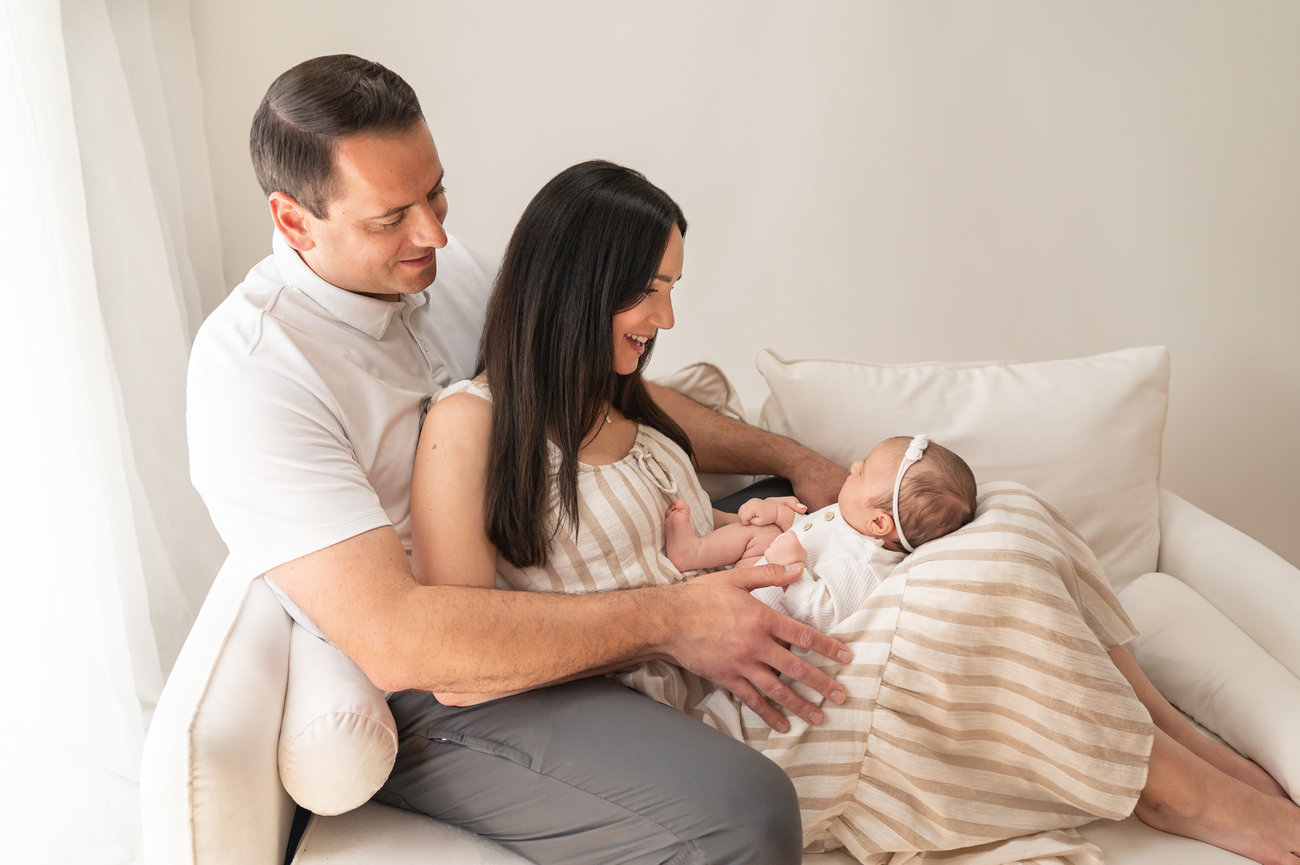 Lifestyle newborn snuggles captured in soft white space in Monmouth County
