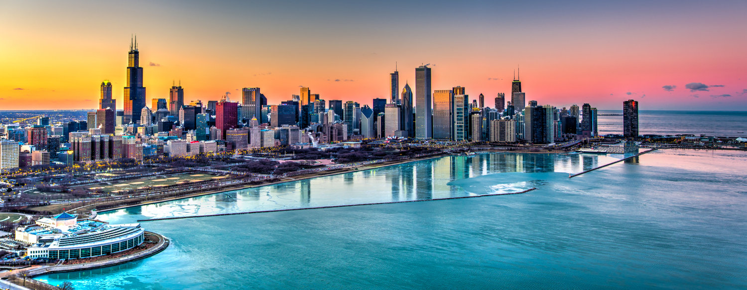 City skyline reflected in lake at sunrise
