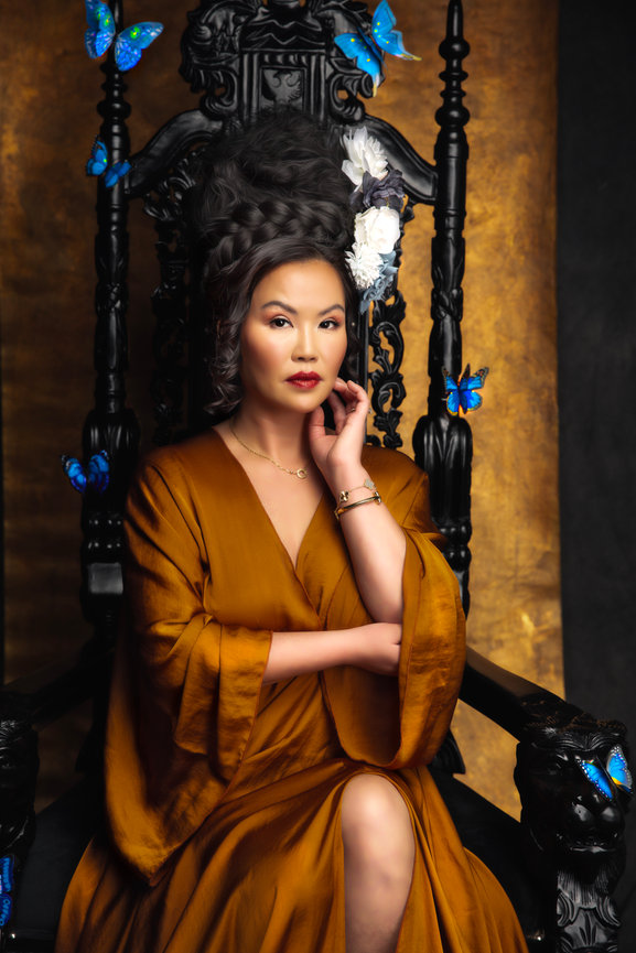 Dramatic studio portrait in Keller with woman seated on ornate black and blue chair.