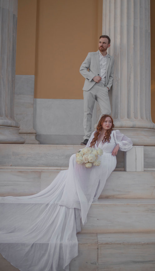 Couple posing on marble steps of a classical building