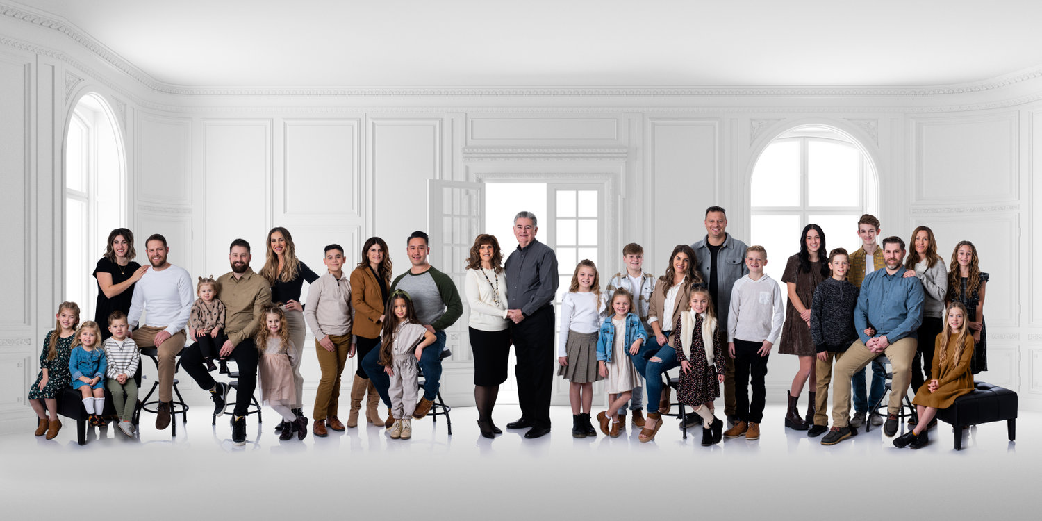 An extended family portrait in a large white room.