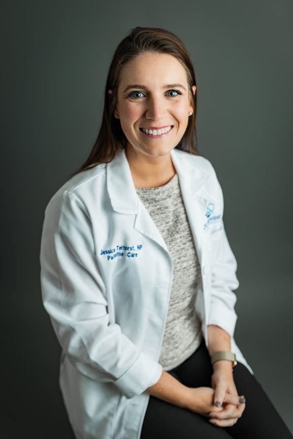 Modern business headshot of woman with long hair and medical coat with clean background