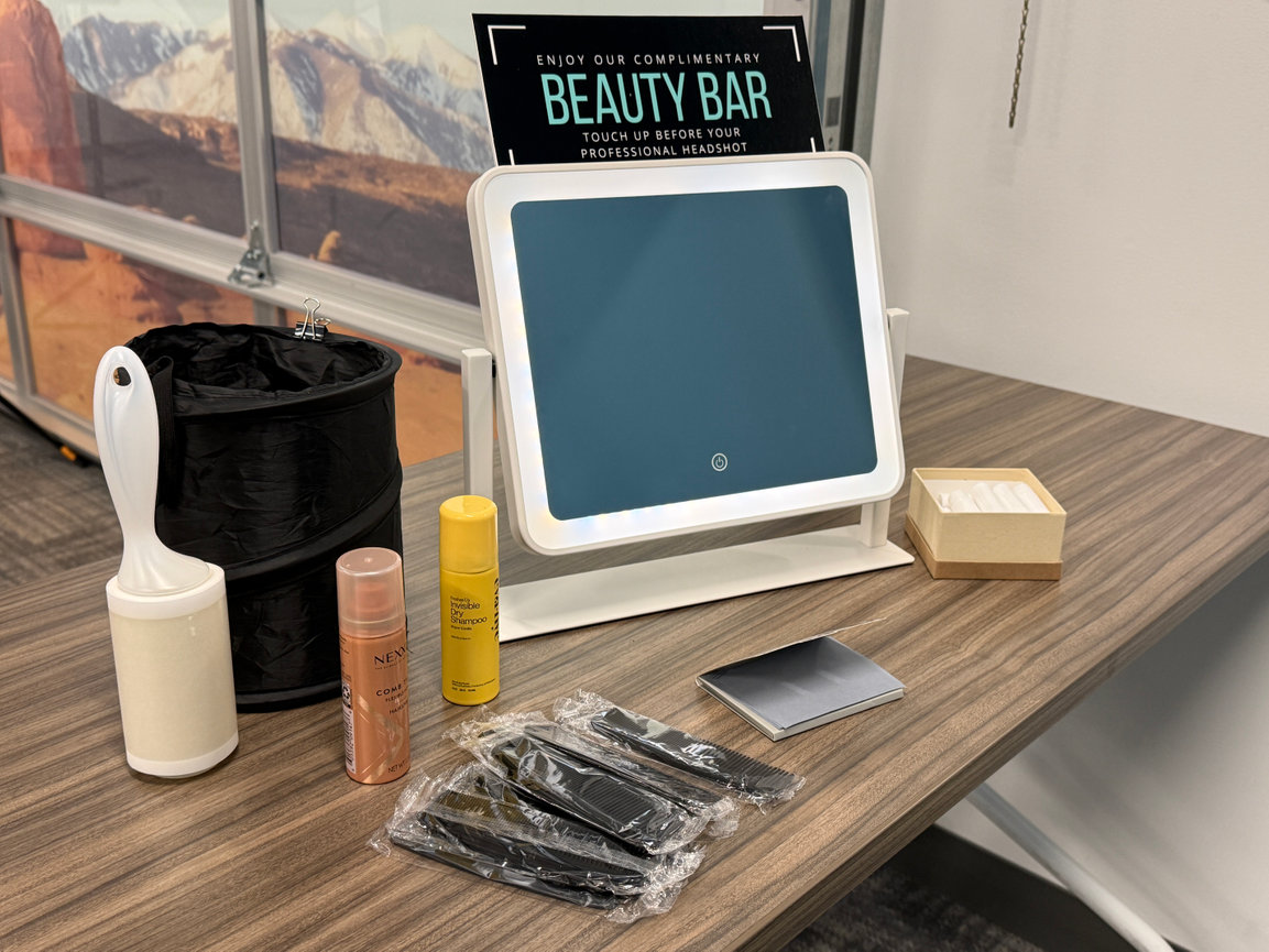Beauty bar setup with mirror, hair products, combs, and styling tools on a table